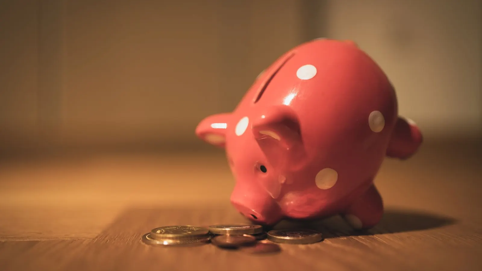 Une tirelire posée à côté de pièces de monnaie
